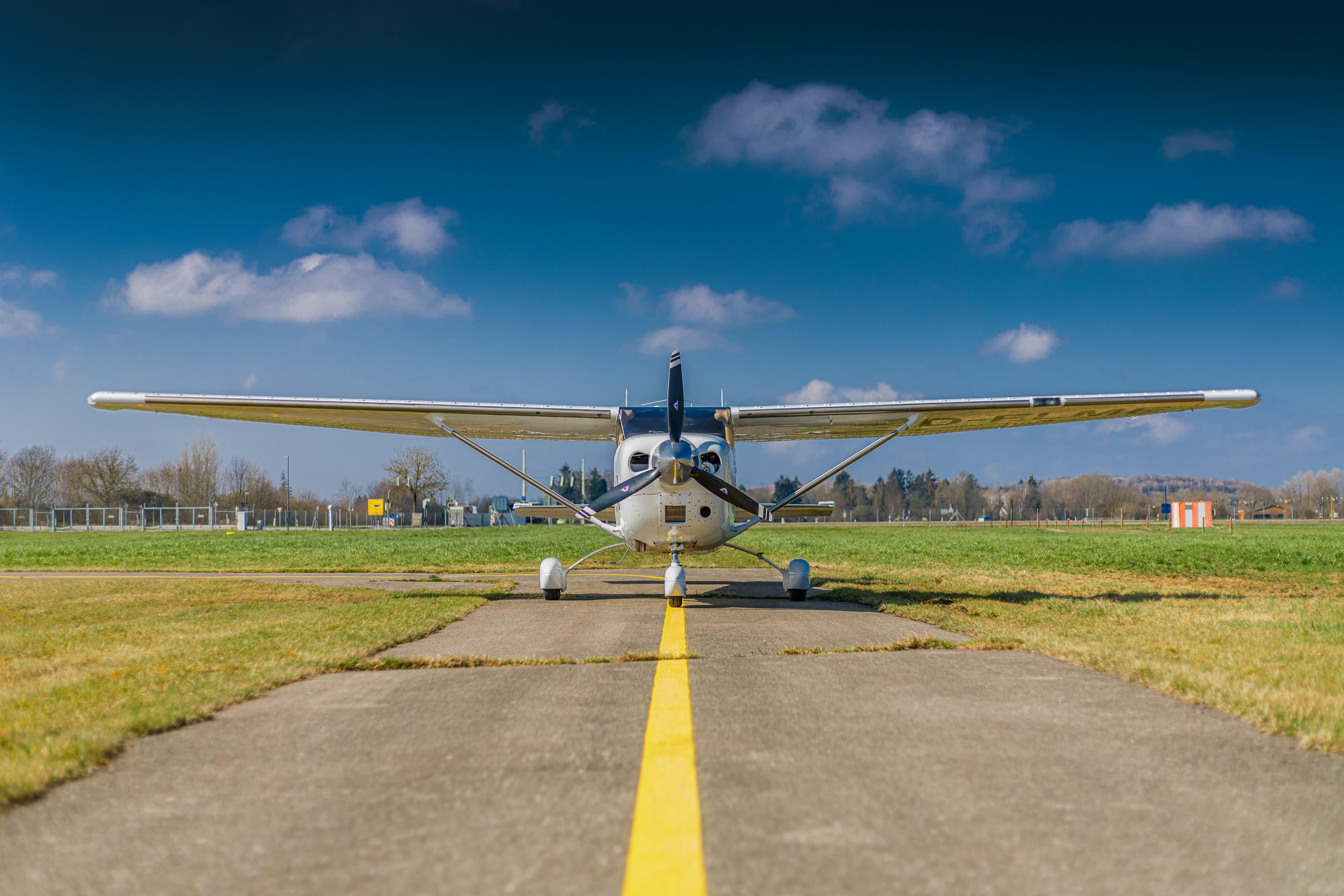 Small Cessna aircraft on a grass airstrip on a clear day